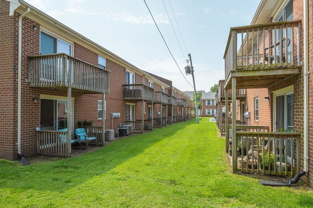 a green lawn in front of a row of brick apartment buildings