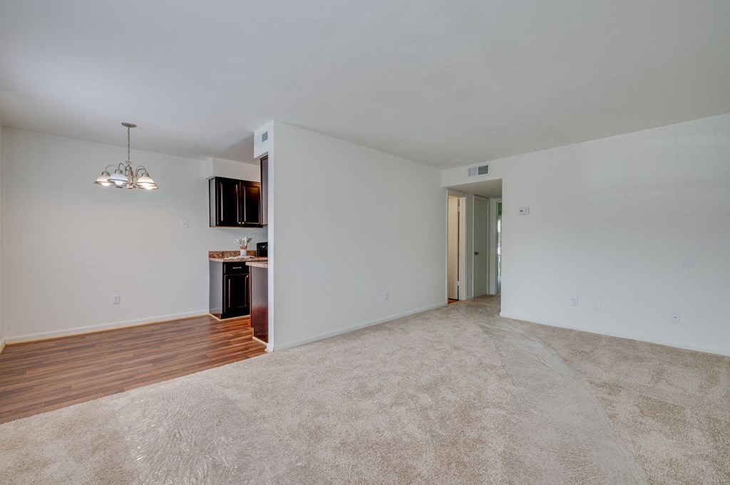 an empty living room with white walls and wood flooring
