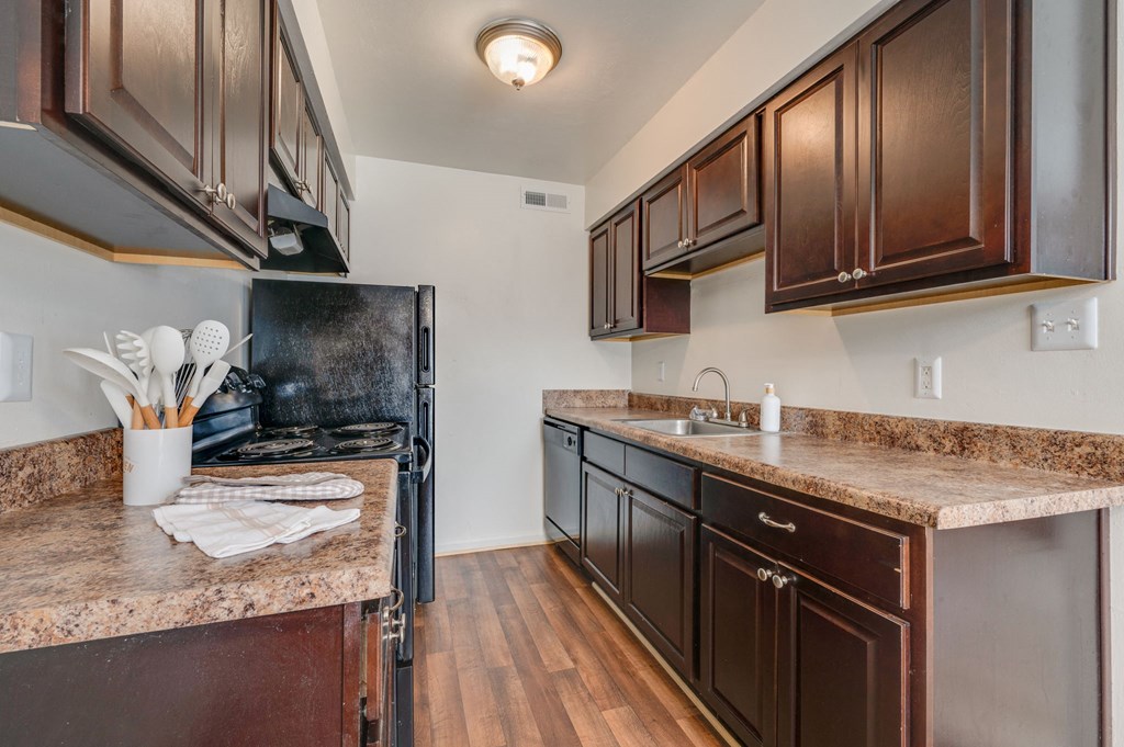 the kitchen of a home with dark wood cabinets and granite counter tops