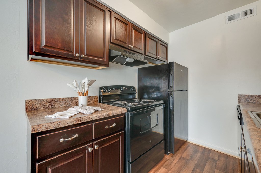 a kitchen with black appliances and wooden cabinets