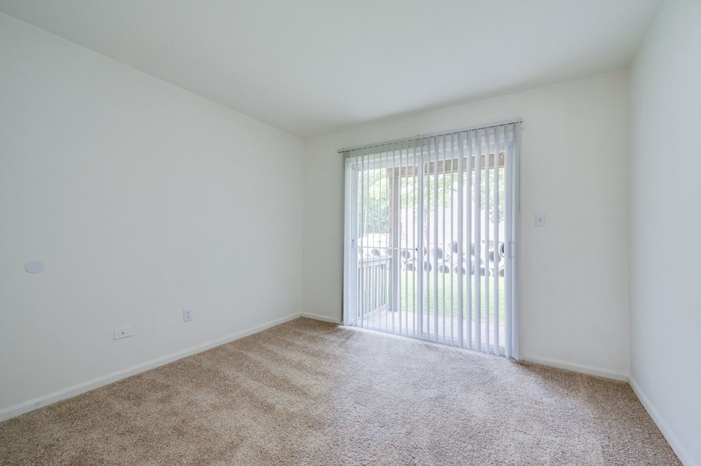 a spacious living room with sliding glass doors to a patio