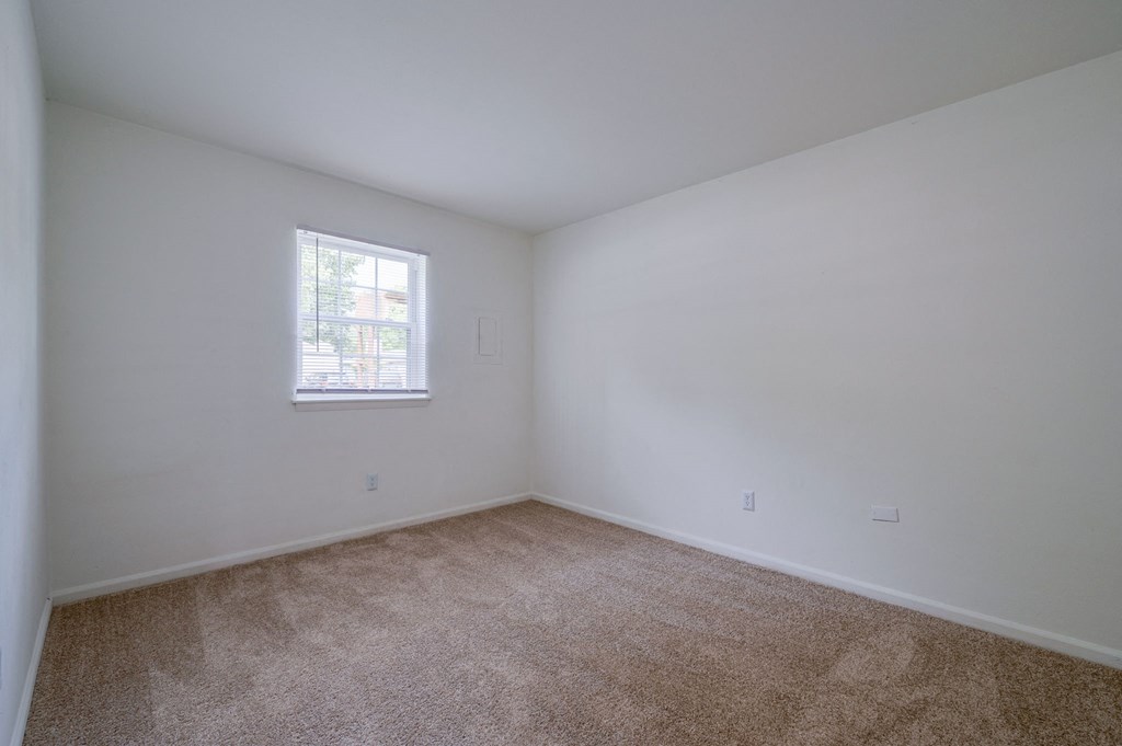 an empty room with carpet and a window