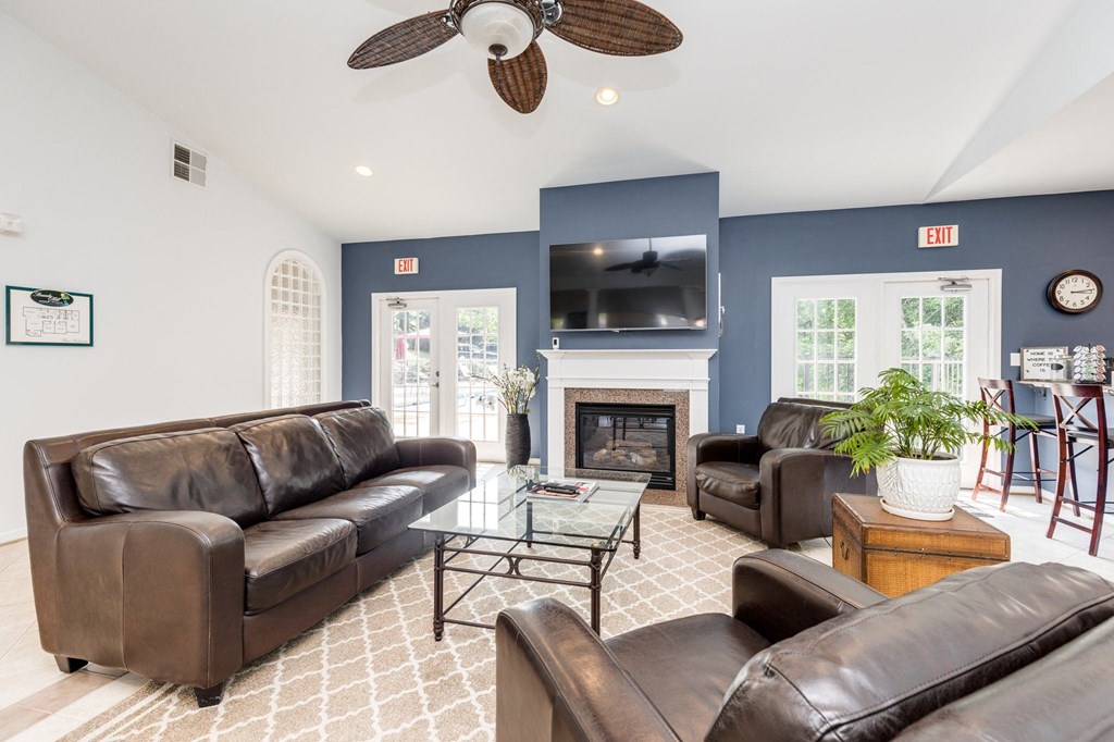 a living room with blue walls and leather furniture and a fireplace