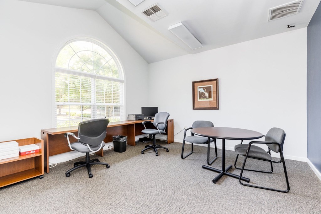 a room with a table and chairs and a window