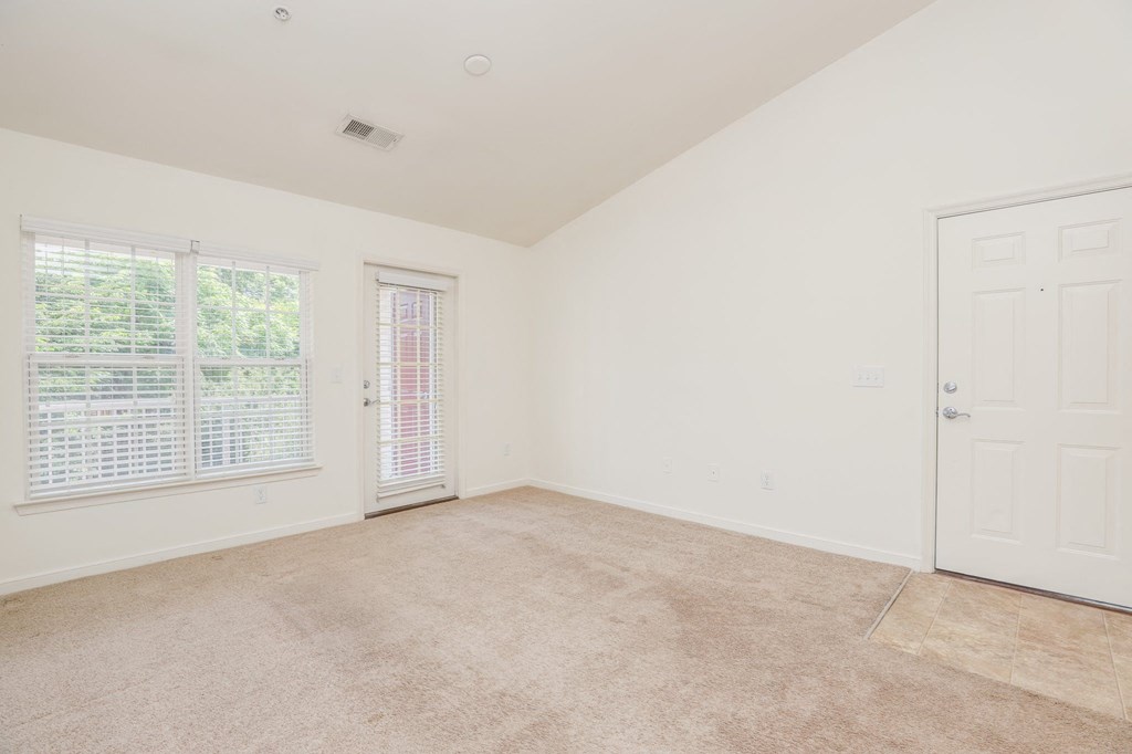 an empty bedroom with a door and a window