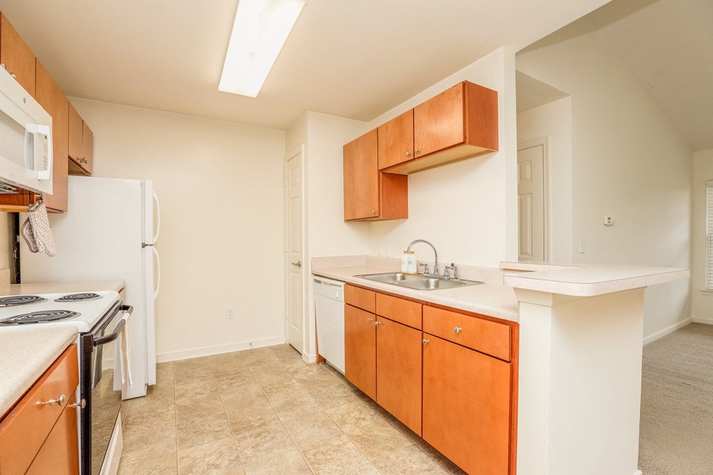 a kitchen with white appliances and wood cabinets