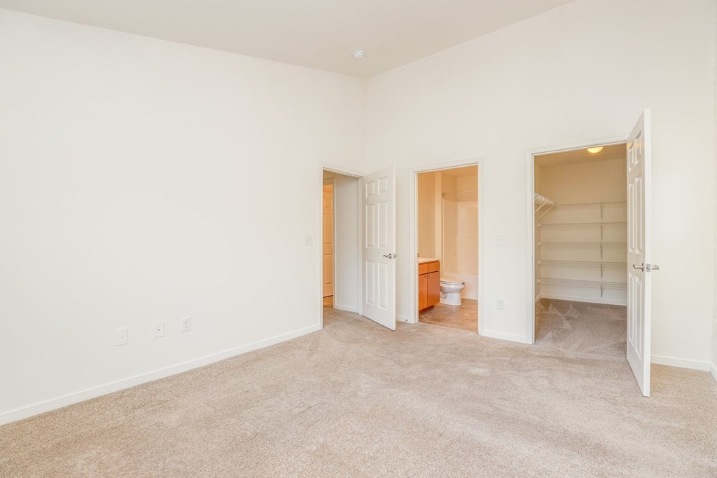 a bedroom with a closet and a bathroom with a toilet