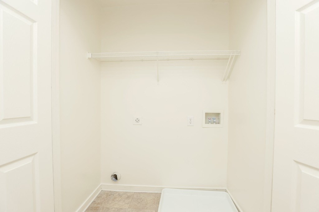a bathroom with a white wall and a white toilet