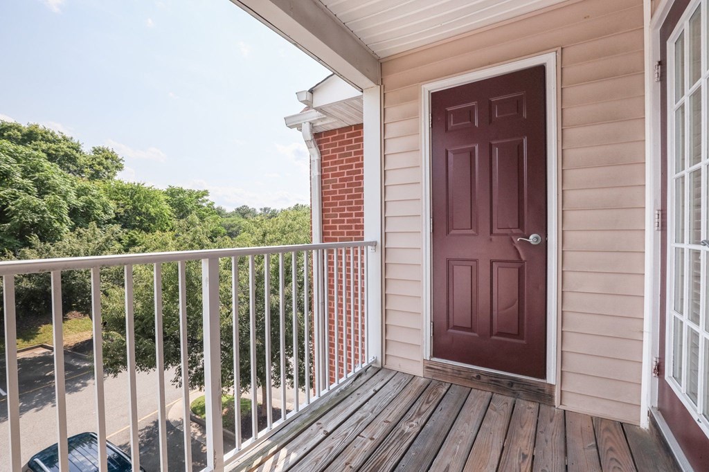 the front door of a home with a deck and a red door