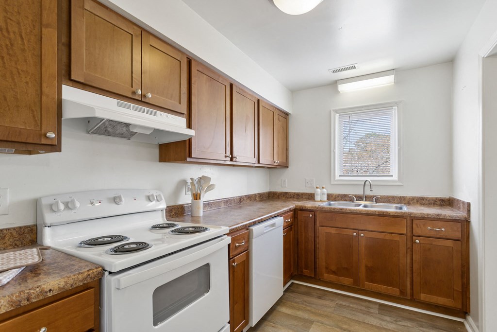 a kitchen with wooden cabinets and a white stove and oven