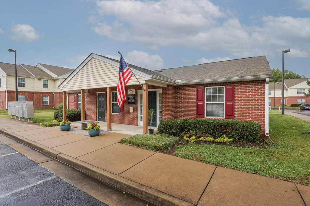 the front of a brick house with an flag in front of it