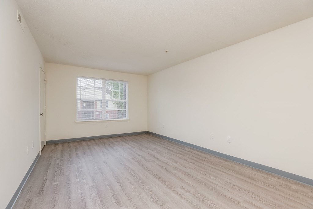 an empty room with wood floors and a window
