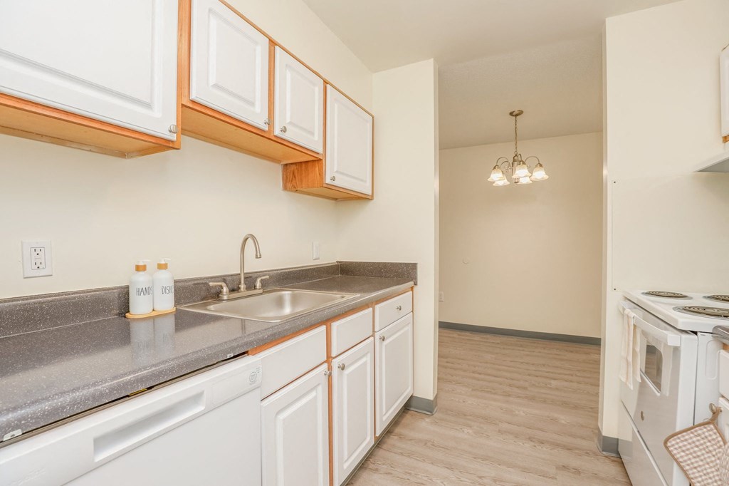 a kitchen with white cabinets and a sink and a stove