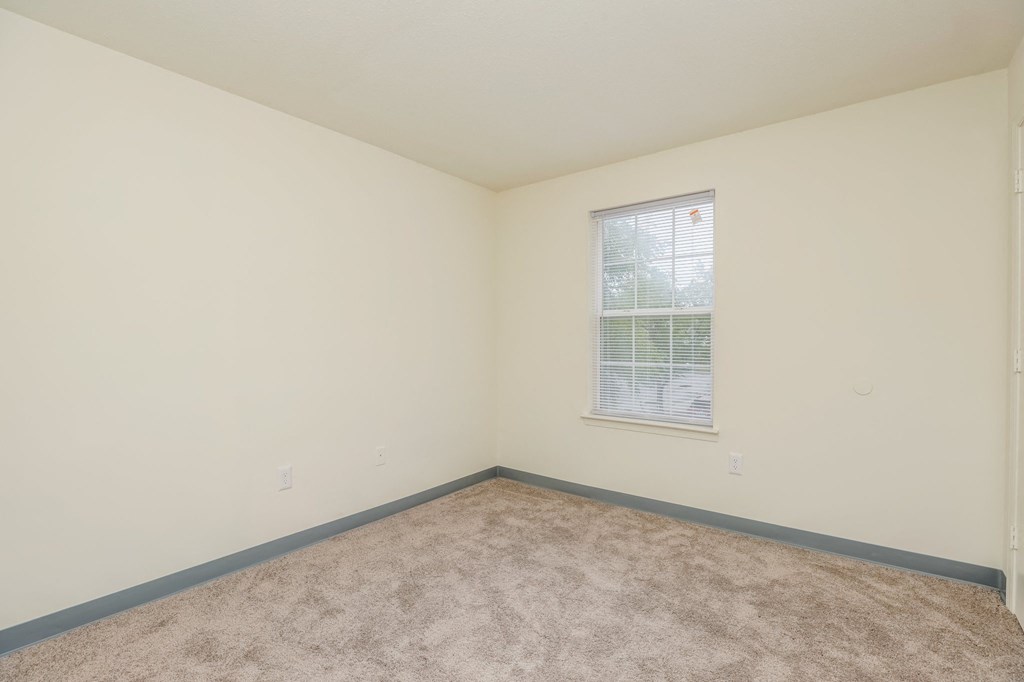 an empty room with carpet and a window