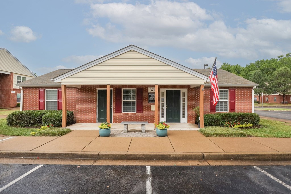 the front of a brick house with an flag in front of it