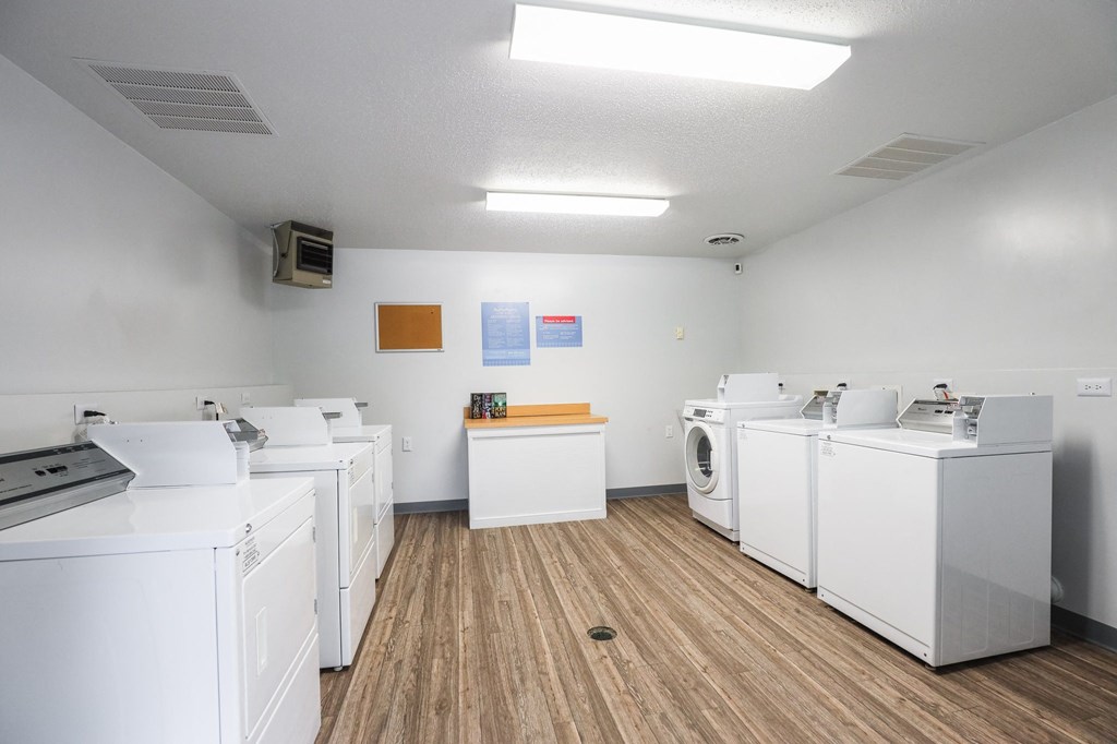 a room filled with washes and dryers in a laundromat