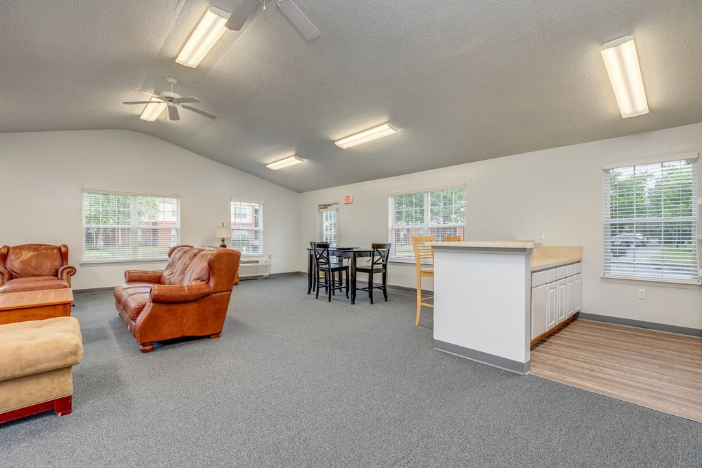 the living room and kitchen of a home with couches and a table and chairs