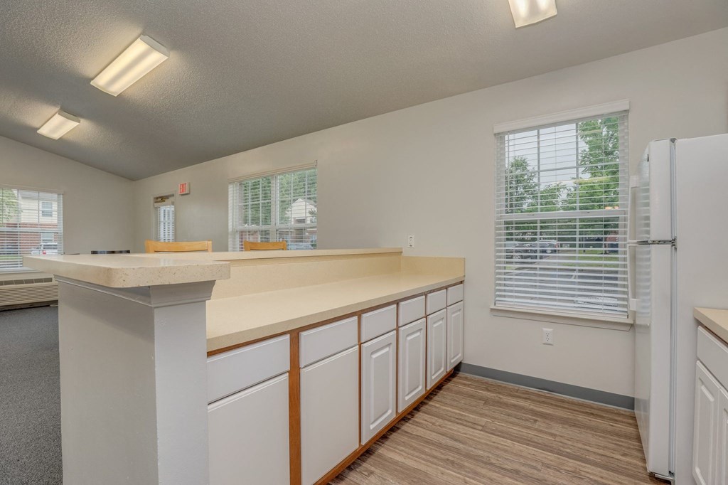 a kitchen with white cabinets and a counter top and a refrigerator