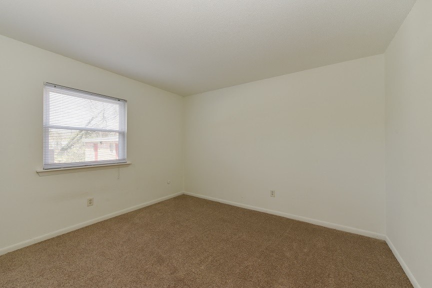an empty room with carpet and a window