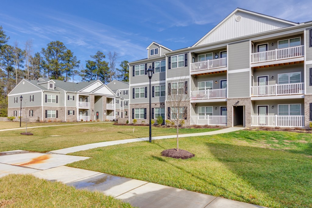 Apartment complex with a tree in front of it.