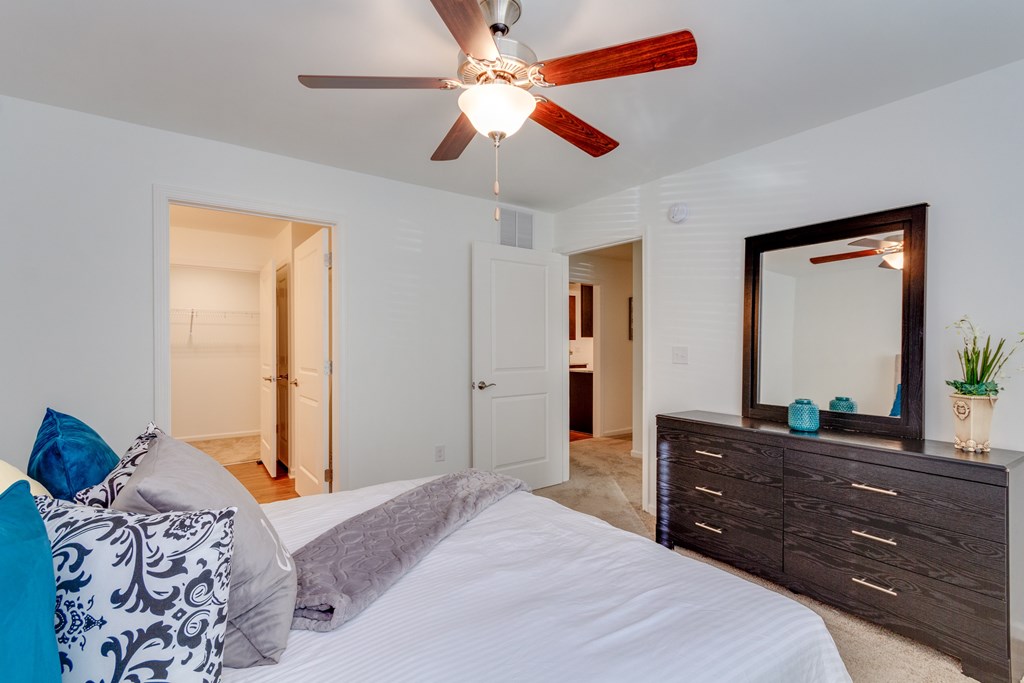 A bedroom with a bed, dresser, and mirror.