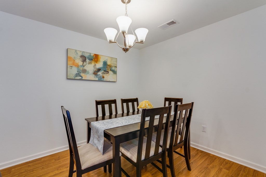 A dining room with a table set for four.