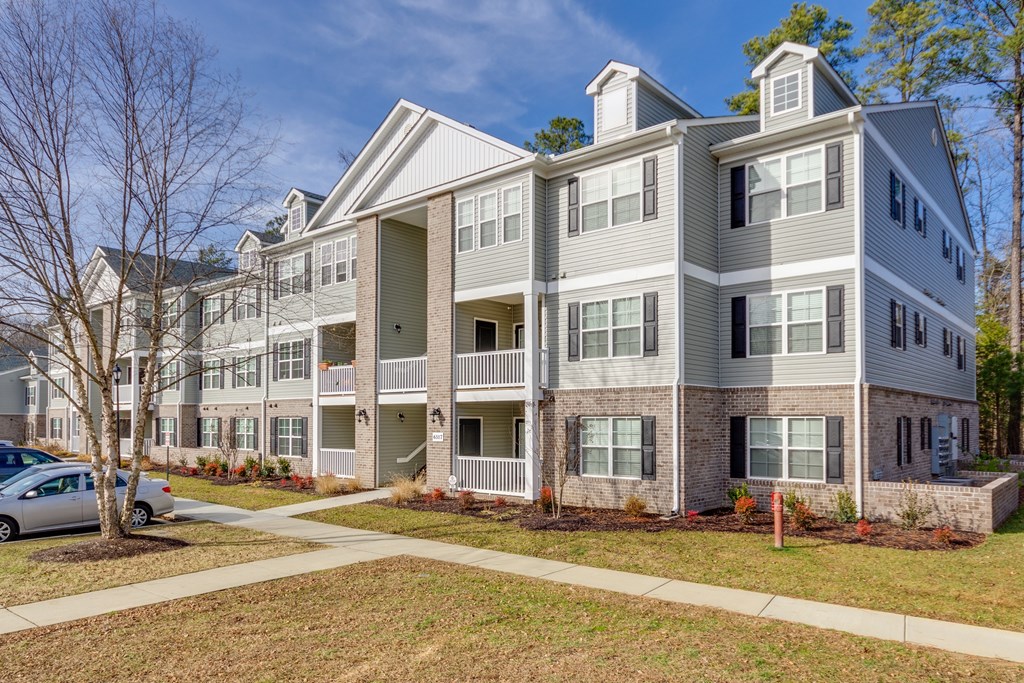 A large apartment complex with a car parked in front.