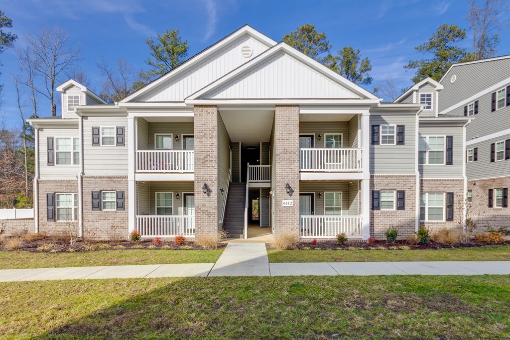 A large two-story house with a front porch and a driveway.