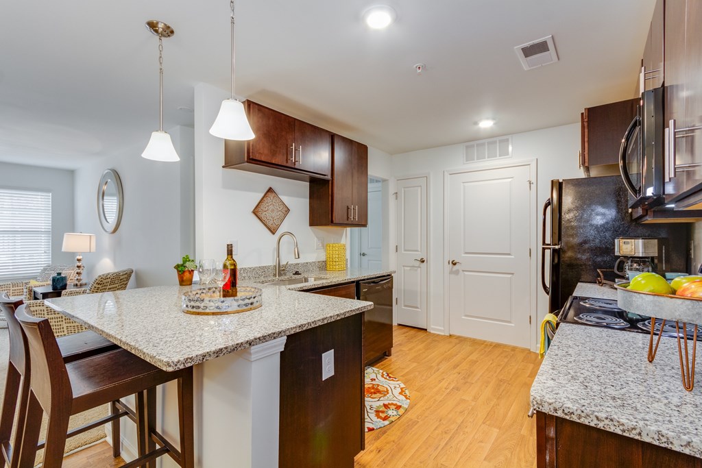 A kitchen with a granite countertop and wooden cabinets.