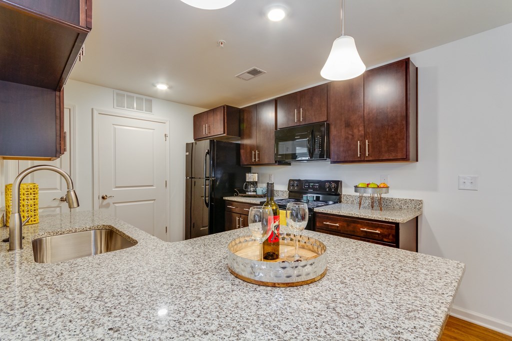 A kitchen with granite countertops and a wooden cabinet.