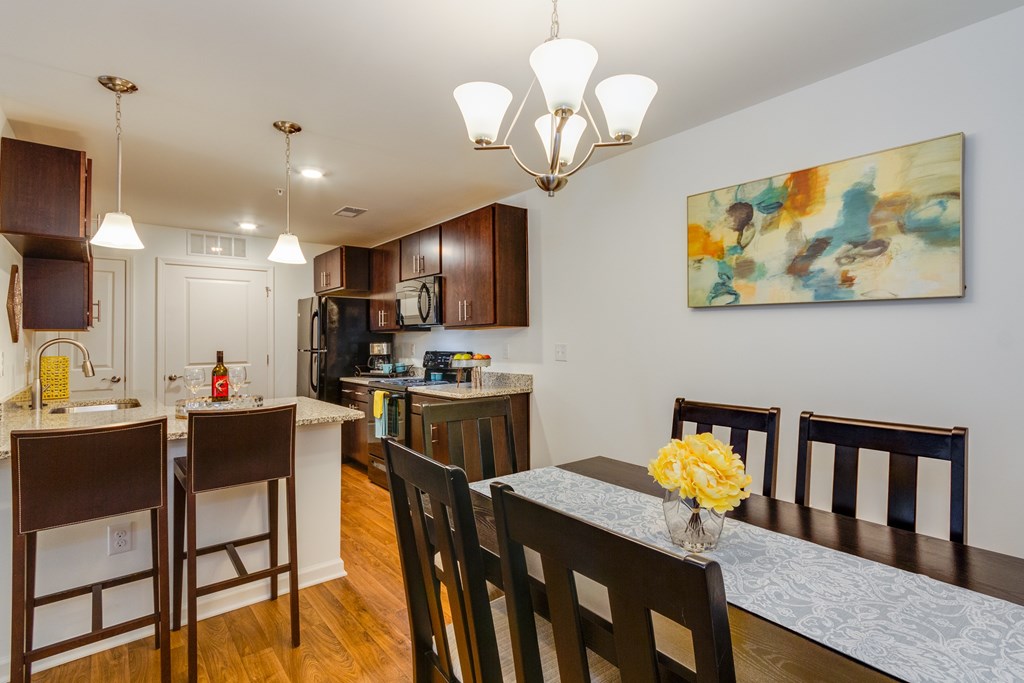 A kitchen with brown chairs and a painting on the wall.