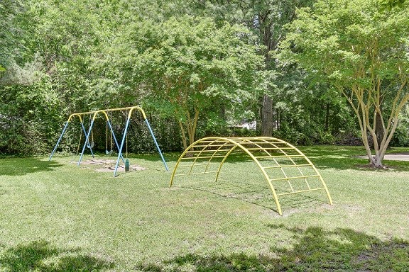 a swing set in a park with trees
