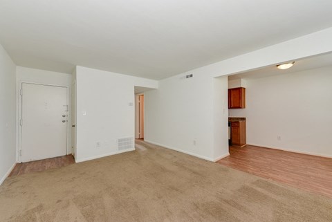 an empty living room with wood flooring and white walls