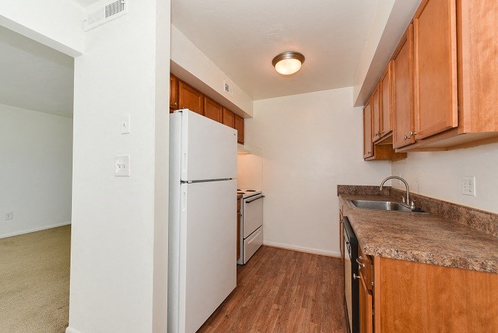 an empty kitchen with a refrigerator and a sink