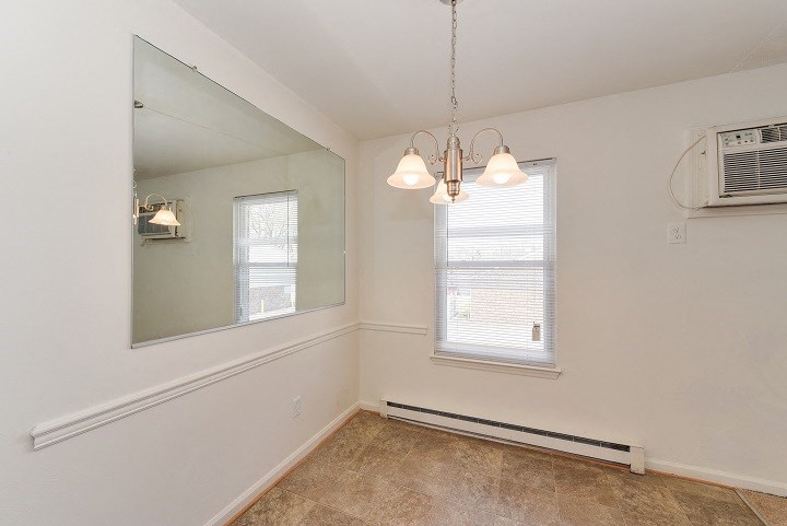 an empty room with a window and a mirror and a air conditioner