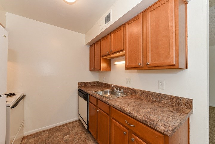 a kitchen with granite counter tops and wooden cabinets