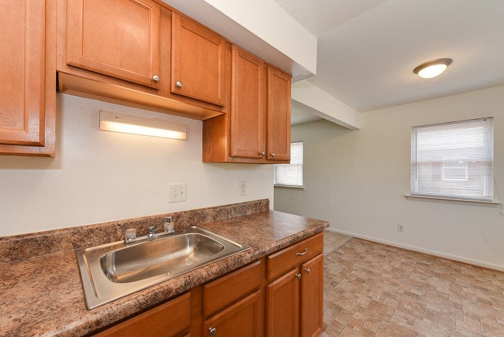 a kitchen with wooden cabinets and a stainless steel sink