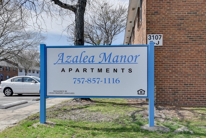 apartments sign in front of a brick building