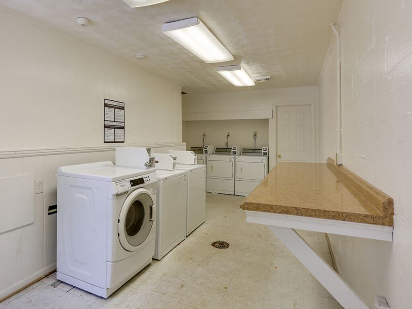 a laundry room with two washing machines and a counter