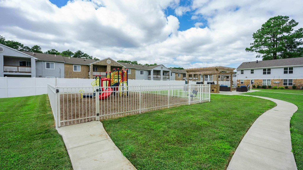 a yard with a swing set in front of houses
