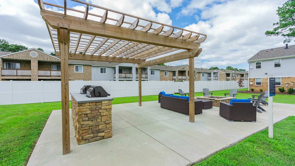 a covered patio with a fire pit and a picnic table