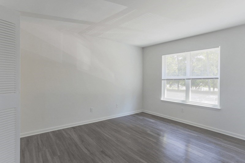 an empty room with white walls and a window