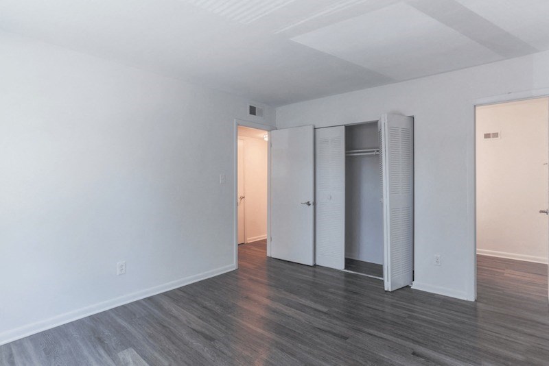 an empty living room with white walls and a closet