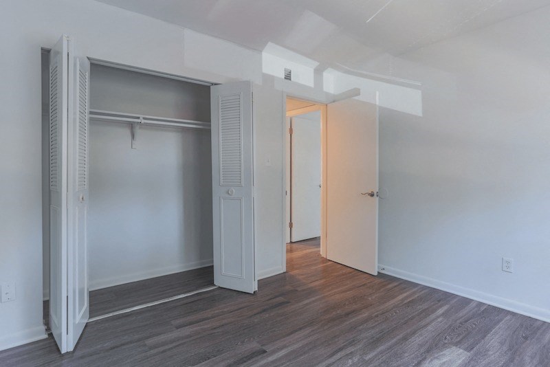 an empty bedroom with a closet and a door to a bathroom