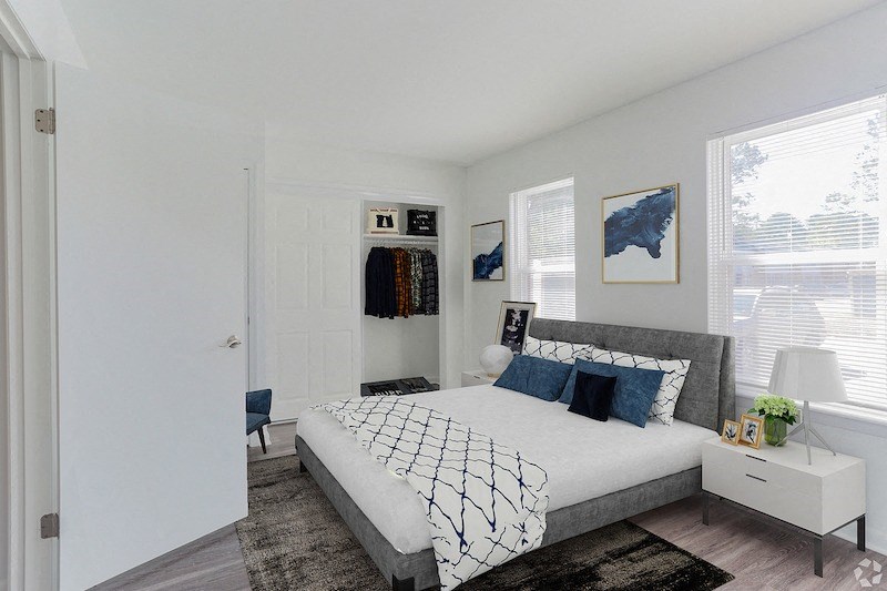 a bedroom with white walls and a bed with blue pillows