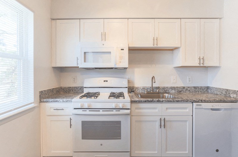 a kitchen with white appliances and granite counter tops