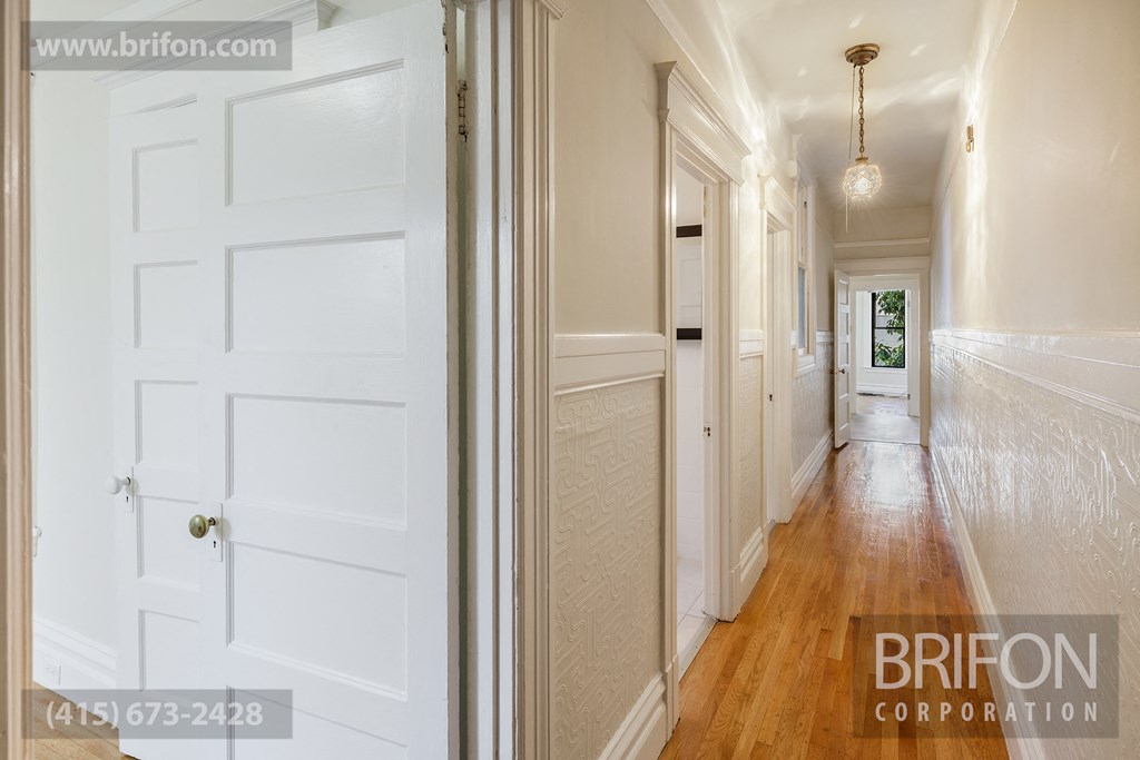 Hallway with Hardwood Floors Leading to Bedrooms