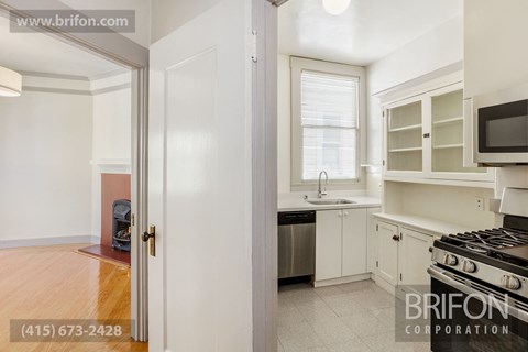 a kitchen with a stove and a sink and a window