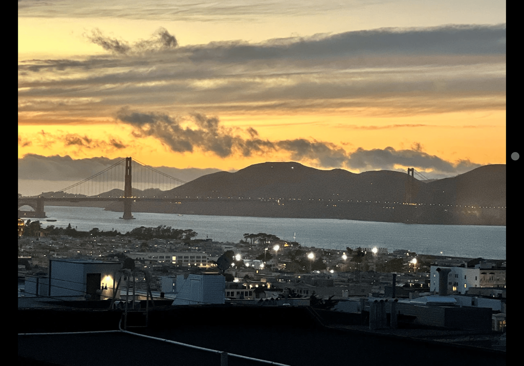 a view of the golden gate bridge and the city at sunset