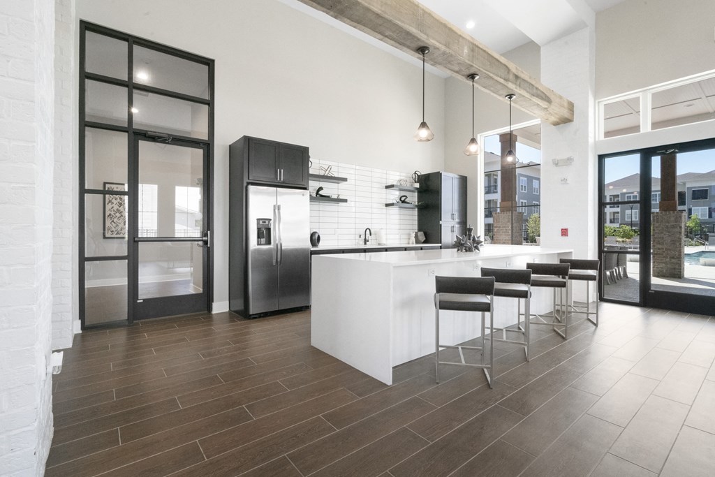 a kitchen with a large white island and stainless steel appliances